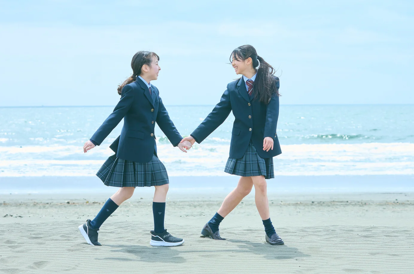 浜辺を歩く二人の女学生