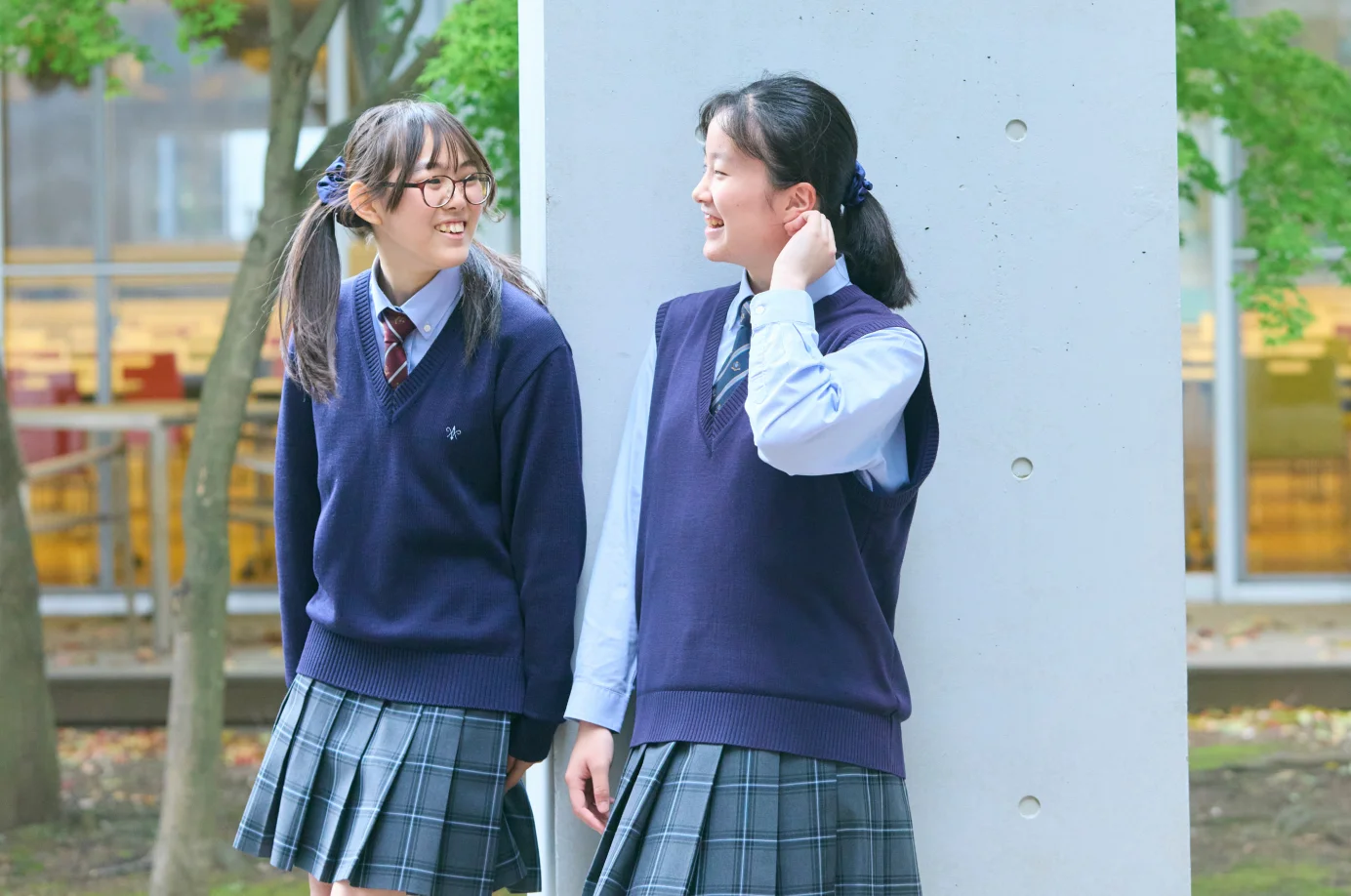 校舎で談笑する女性と二人