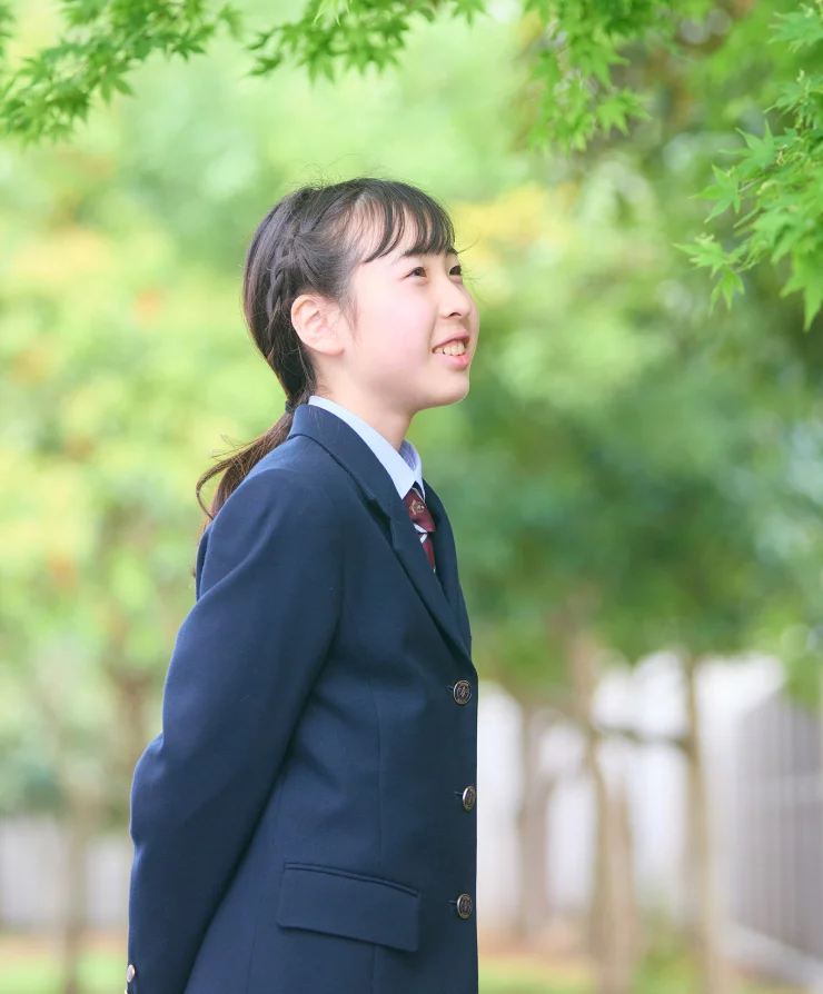 緑を背に微笑む湘南学園の女子生徒