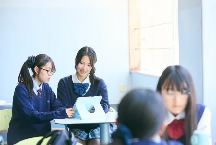 ノートパソコンで話し合う生徒たち